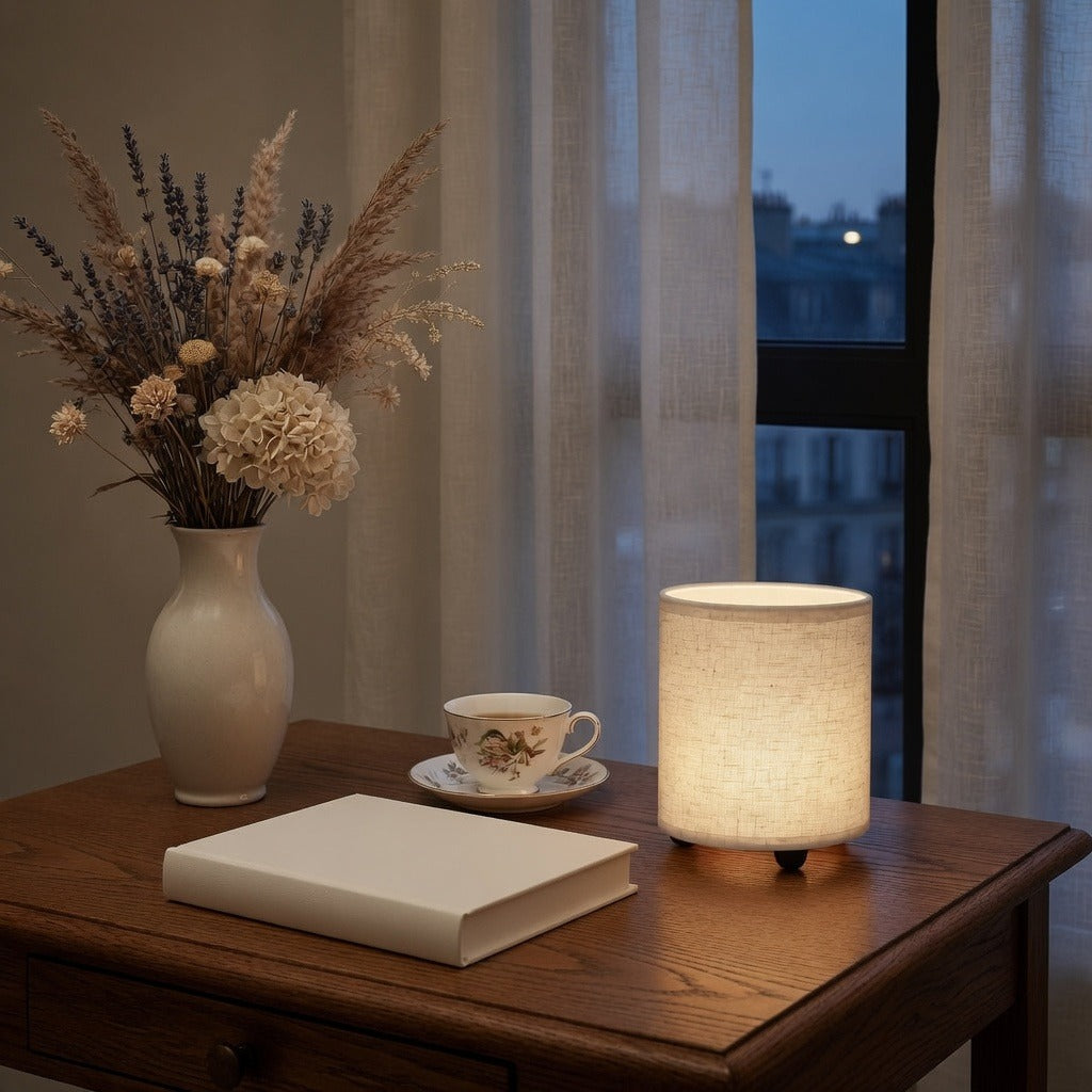 Lampe de chevet en lin allumée sur une table de nuit